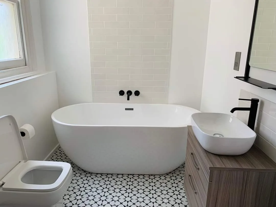 Modern bathroom featuring a freestanding bathtub and stylish sink with patterned tiles