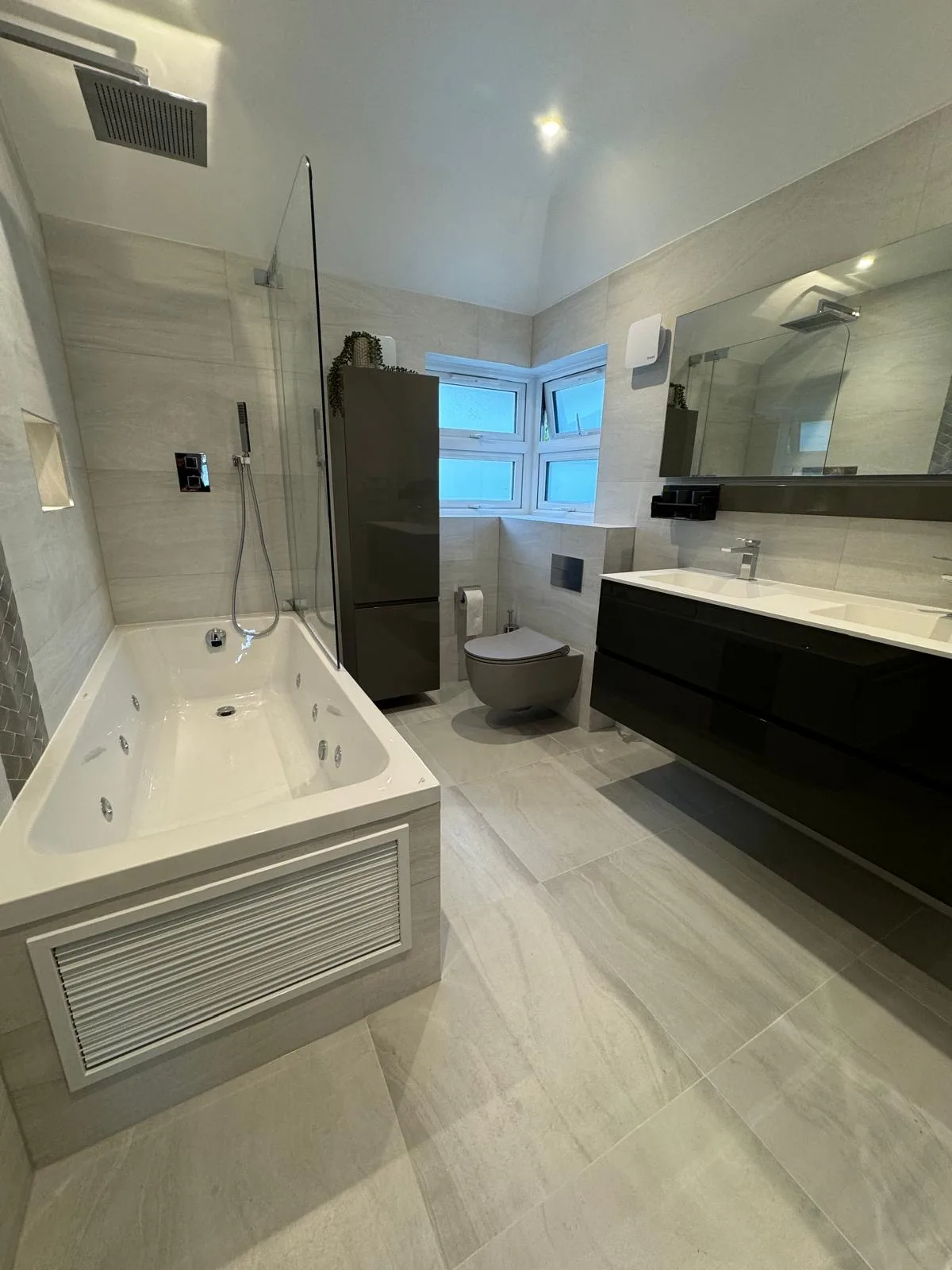 Modern bathroom featuring a jacuzzi tub, stylish black vanity, and sleek fixtures