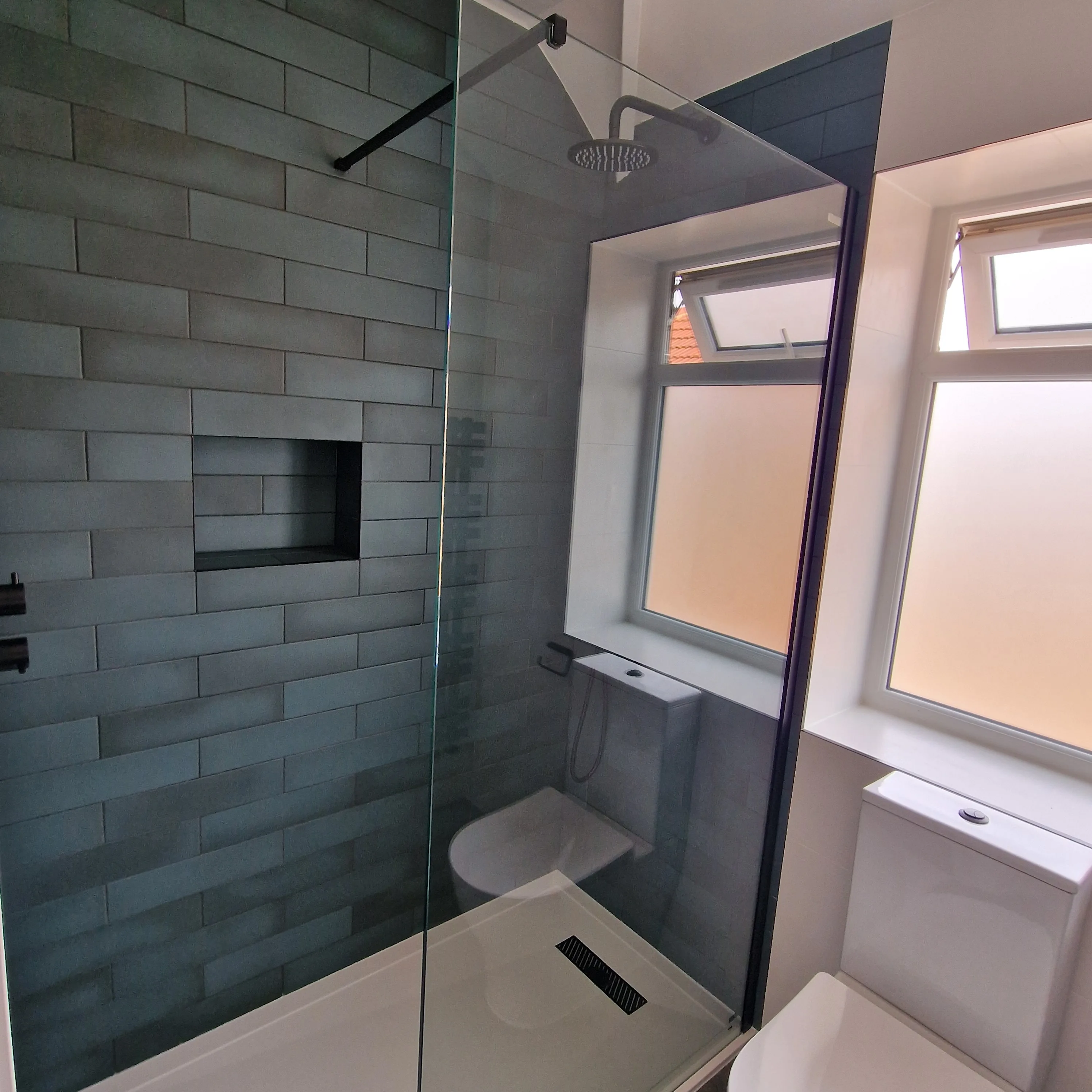 Modern bathroom renovation featuring a walk-in shower with glass enclosure and stylish tiles