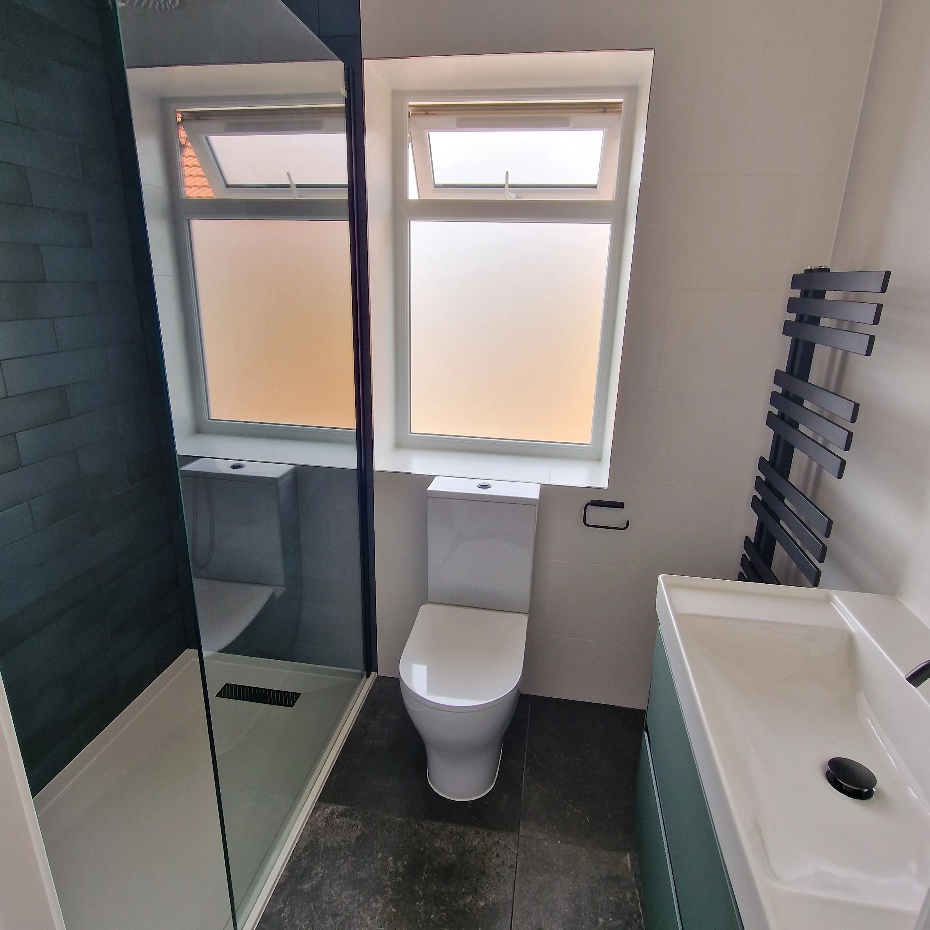 Modern bathroom renovation featuring a sleek design with a shower, toilet, and stylish washbasin
