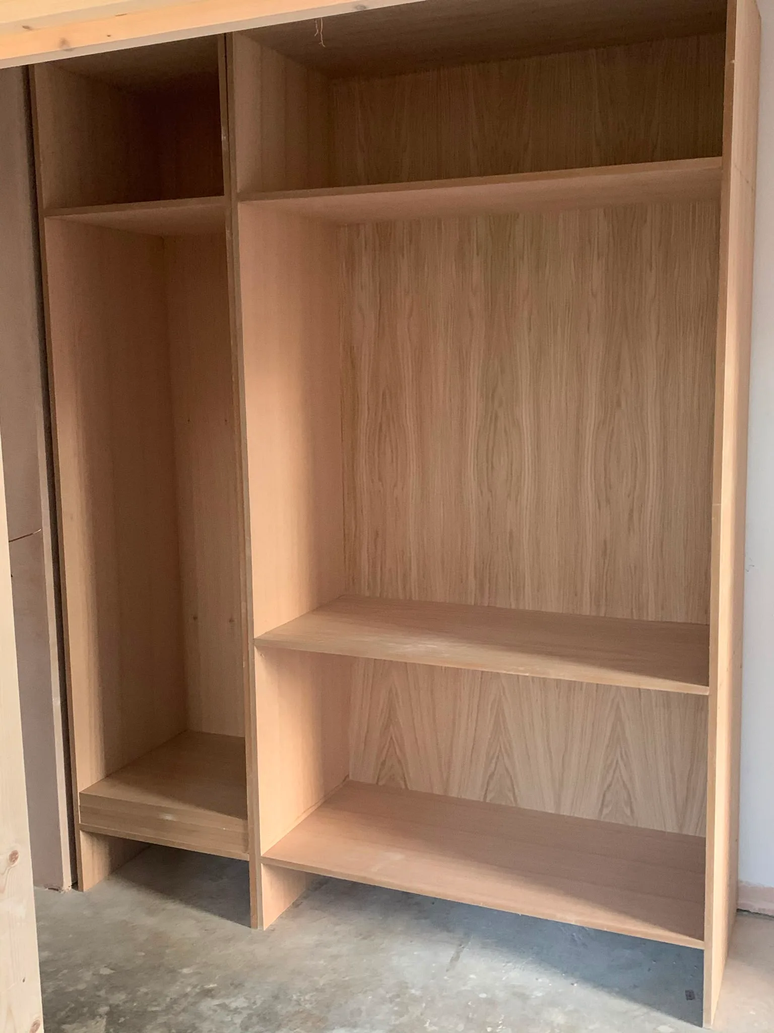 Unfinished bespoke wardrobes made of wood, showcasing a sleek design and ample storage space