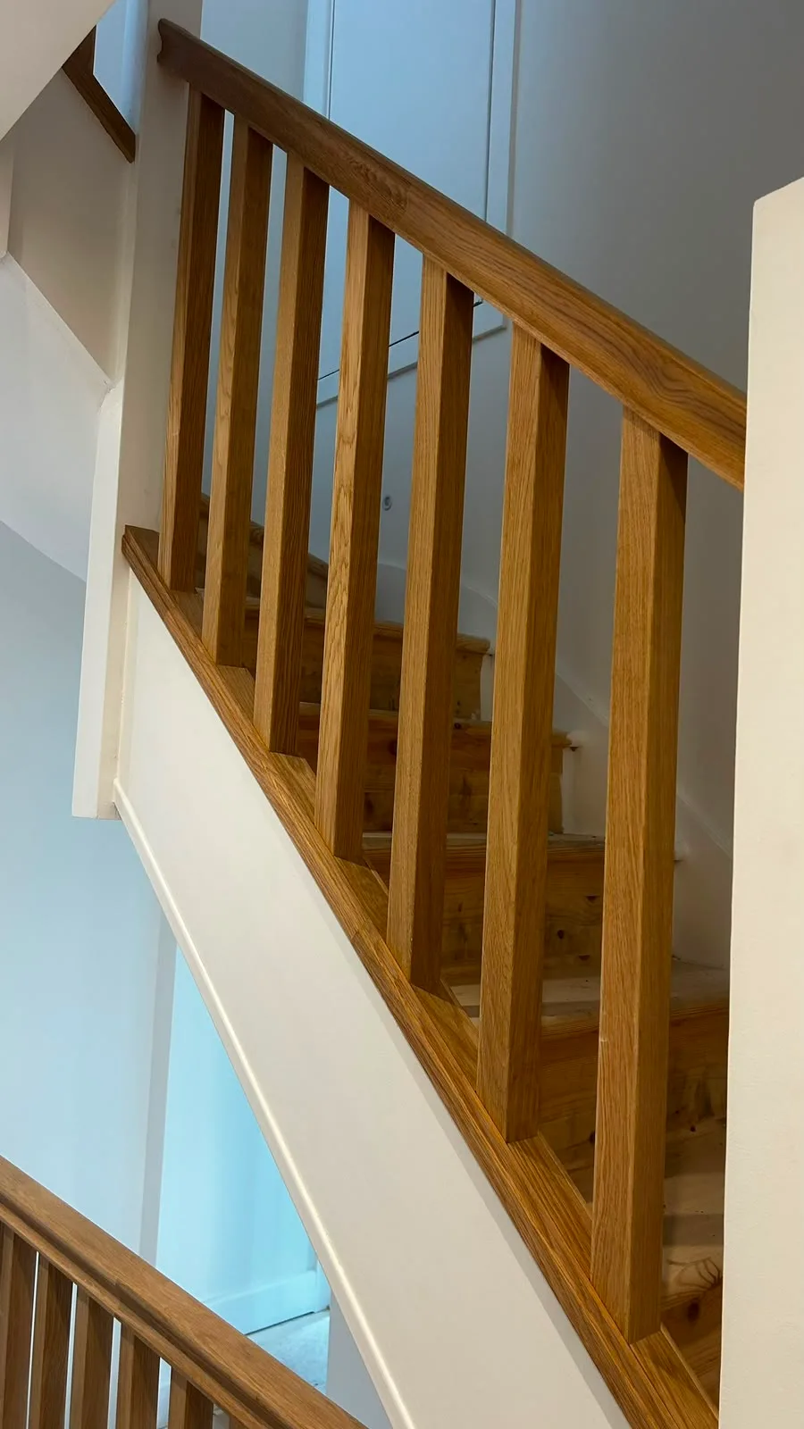 Wooden staircase with a modern railing leading to the upper level of a home