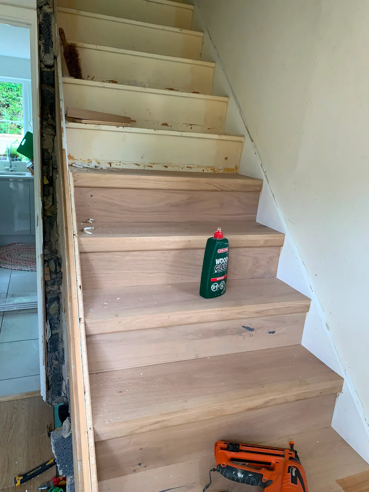 Stairs under renovation with wood cleaner and tools visible on the steps