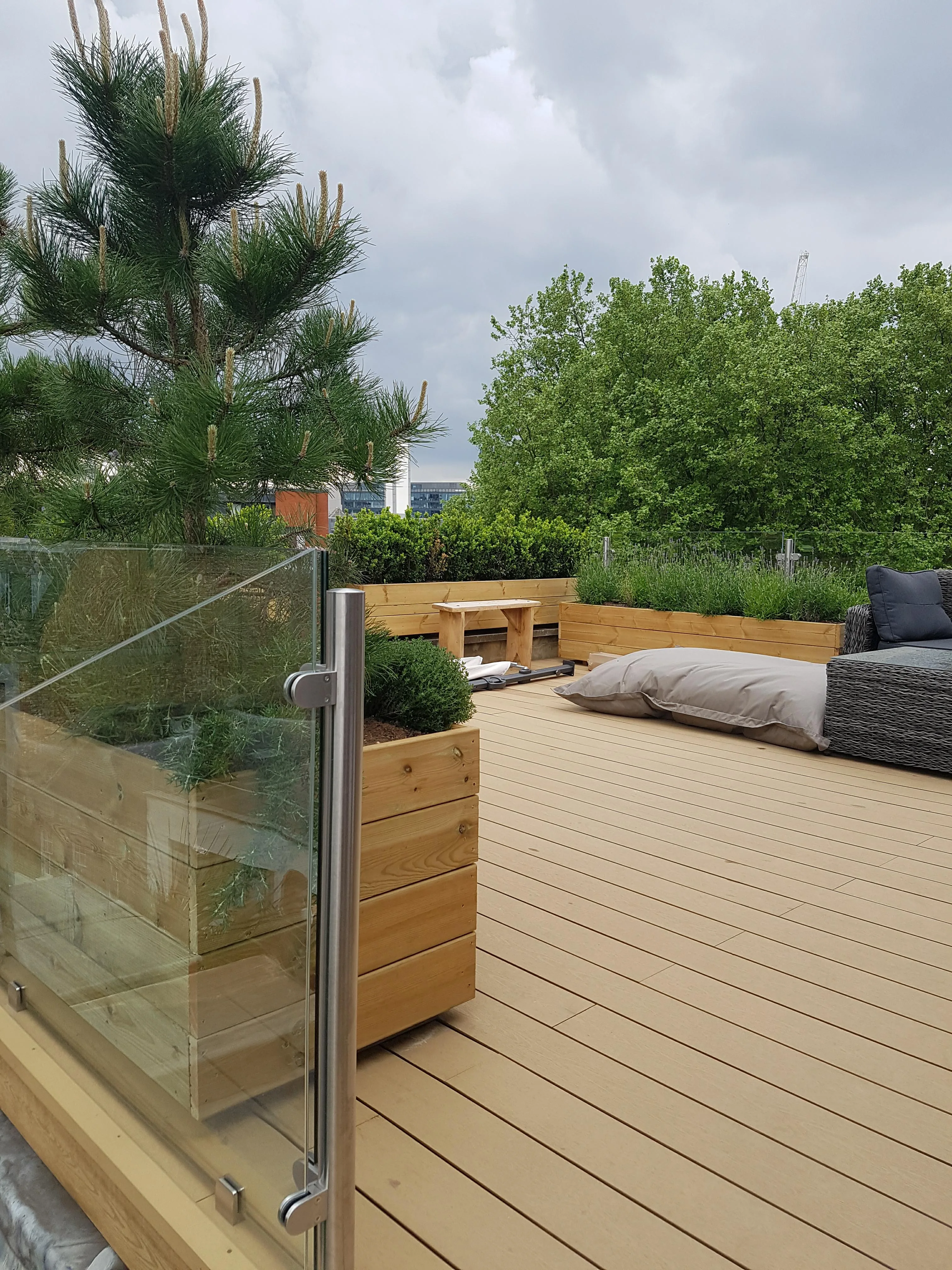Modern deck area with wooden flooring, potted plants, and comfortable seating for outdoor relaxation
