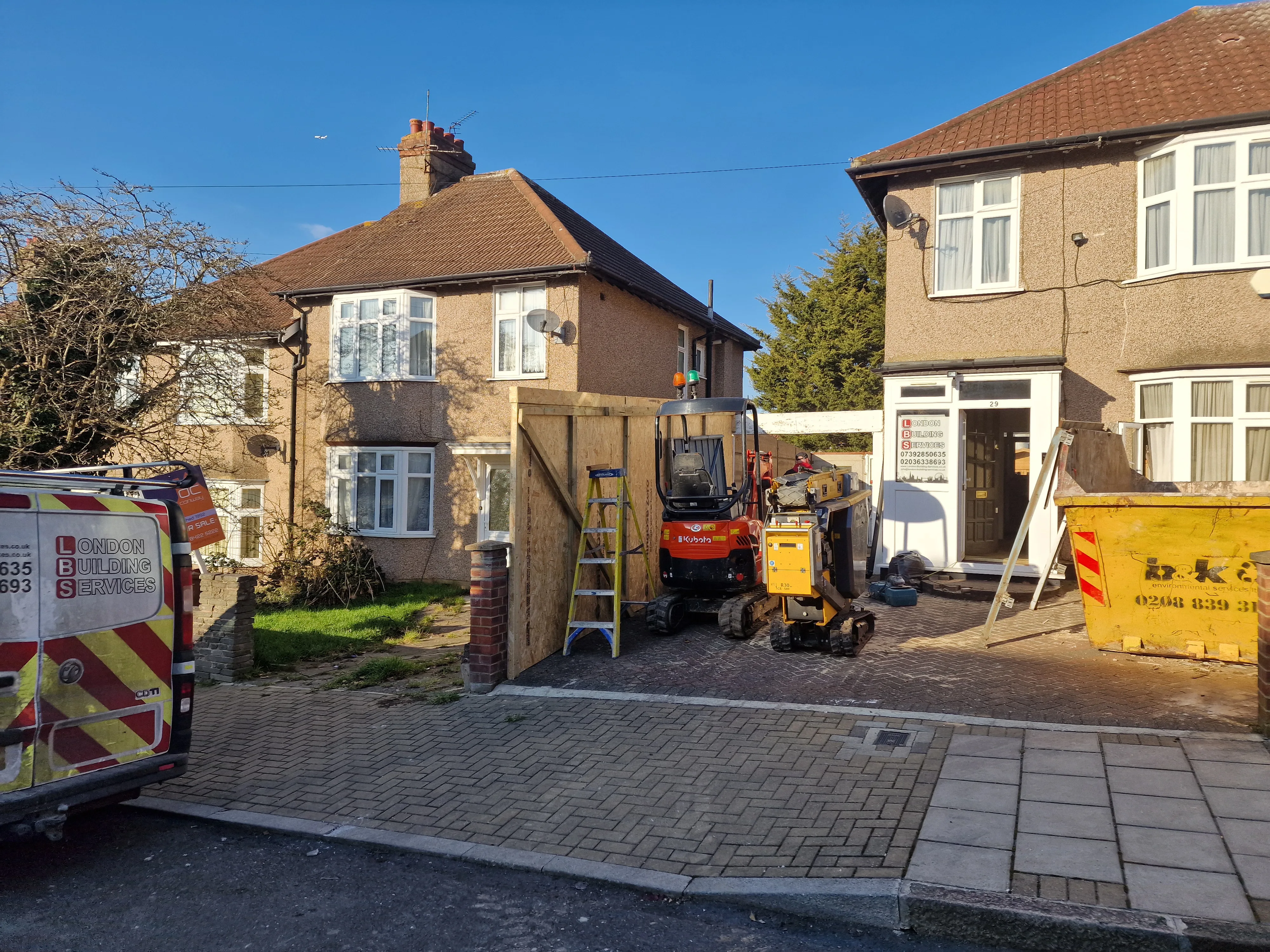 Construction site with a digger and scaffolding for house extension project