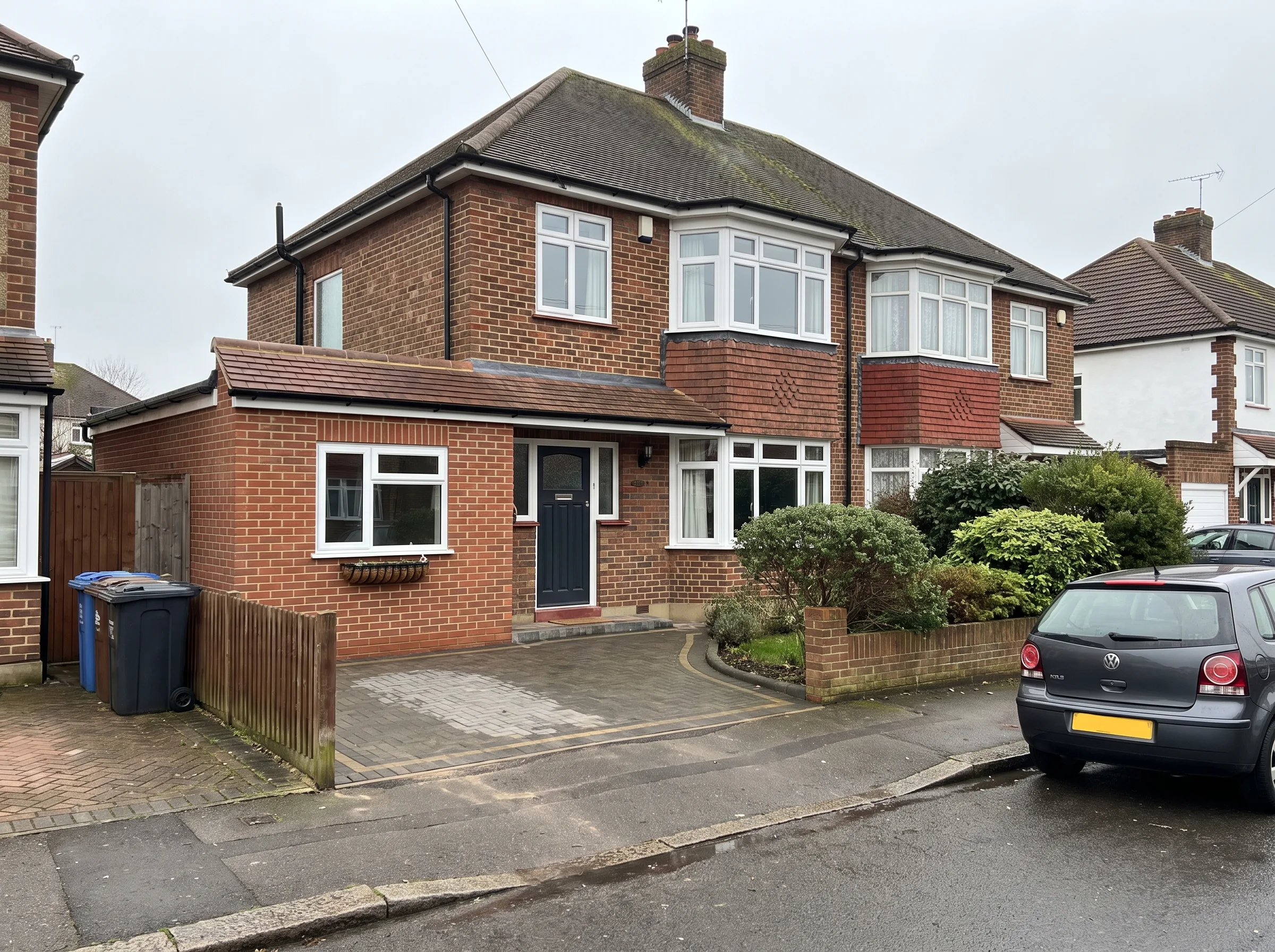 Exterior view of a renovated house with a well-maintained garden and driveway