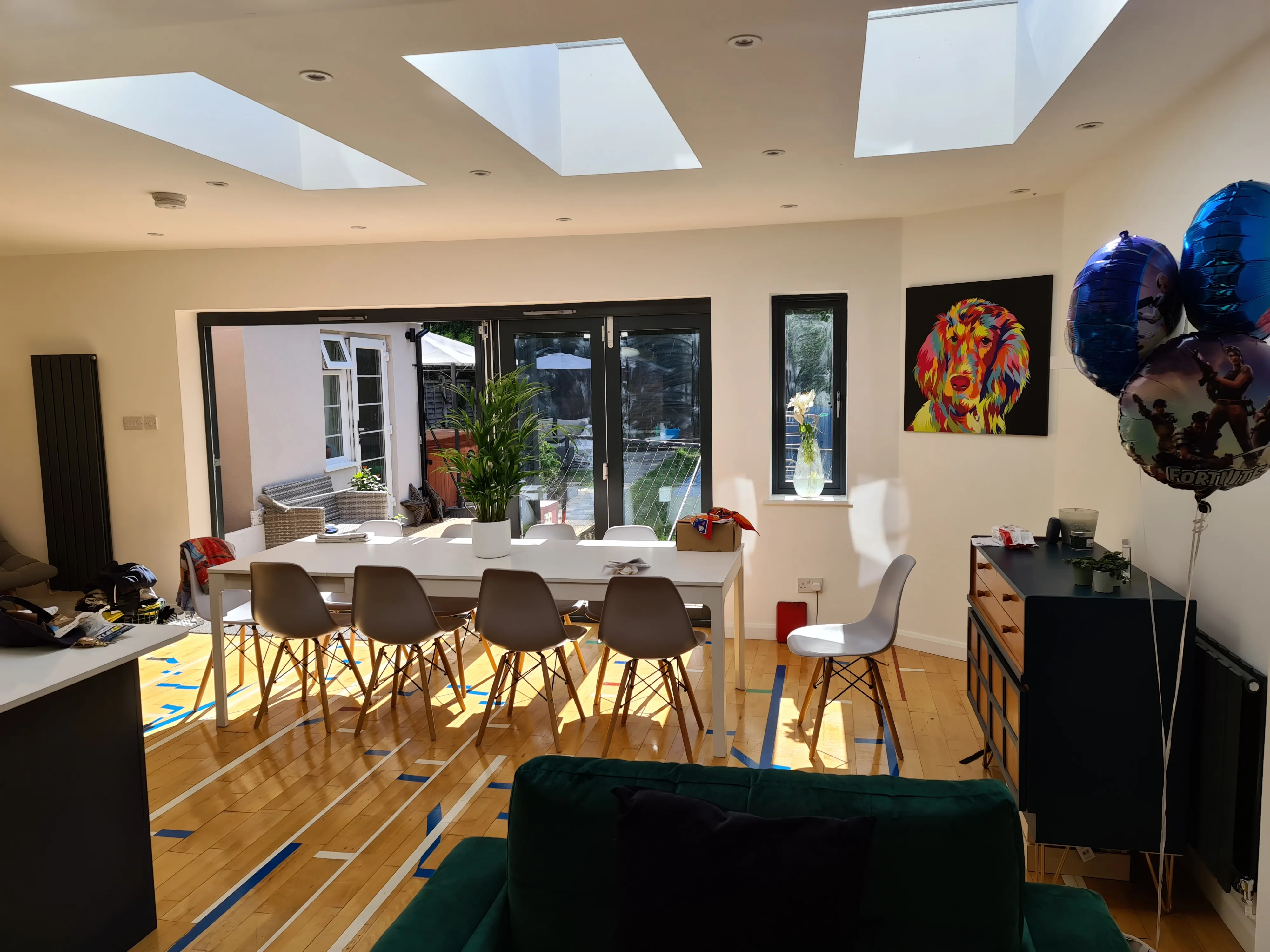 Modern dining area with large windows and skylights, featuring stylish furniture and bright decor