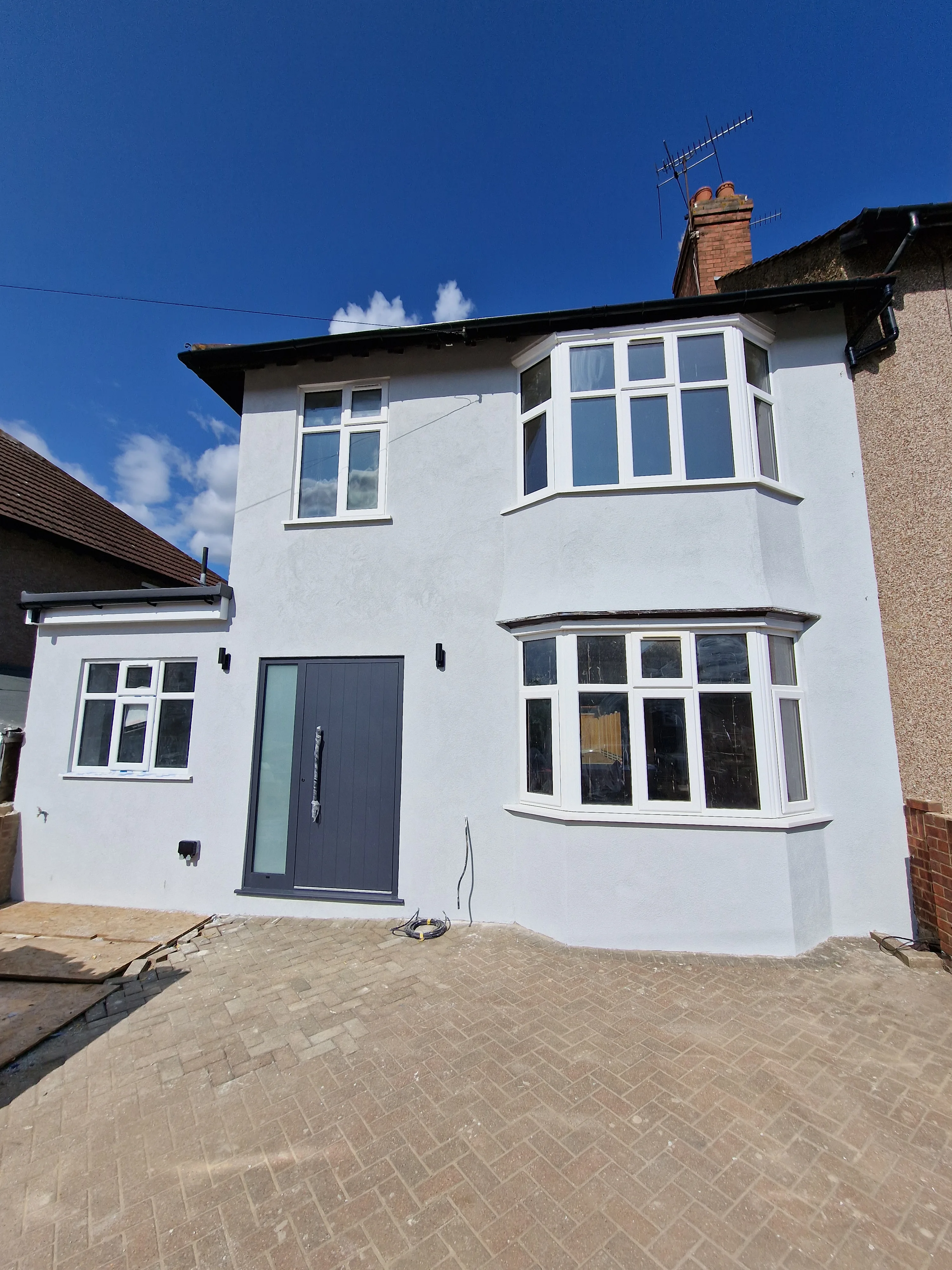 Newly renovated house exterior featuring modern windows and a stylish front door