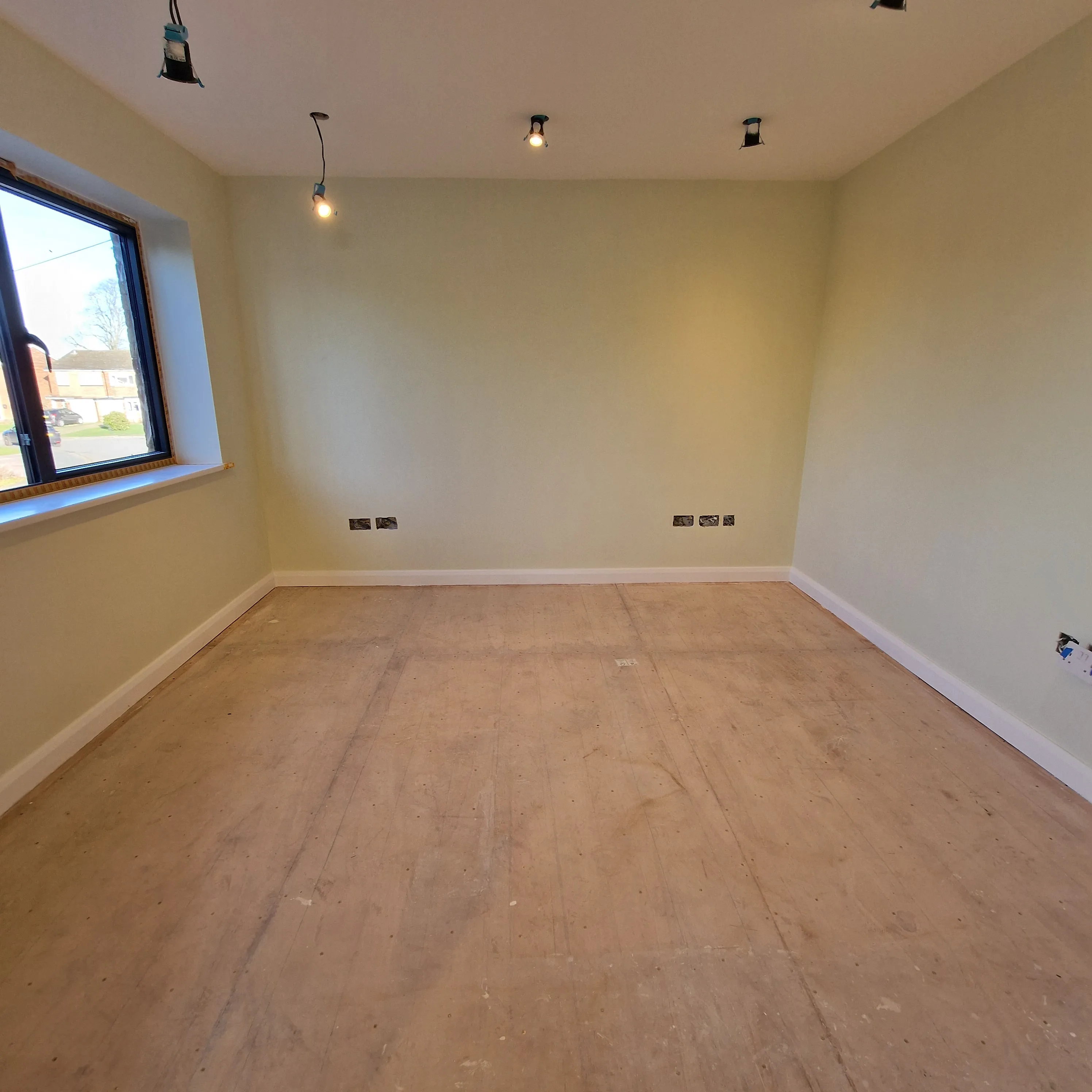 Empty room ready for renovation with green walls and pendant lights
