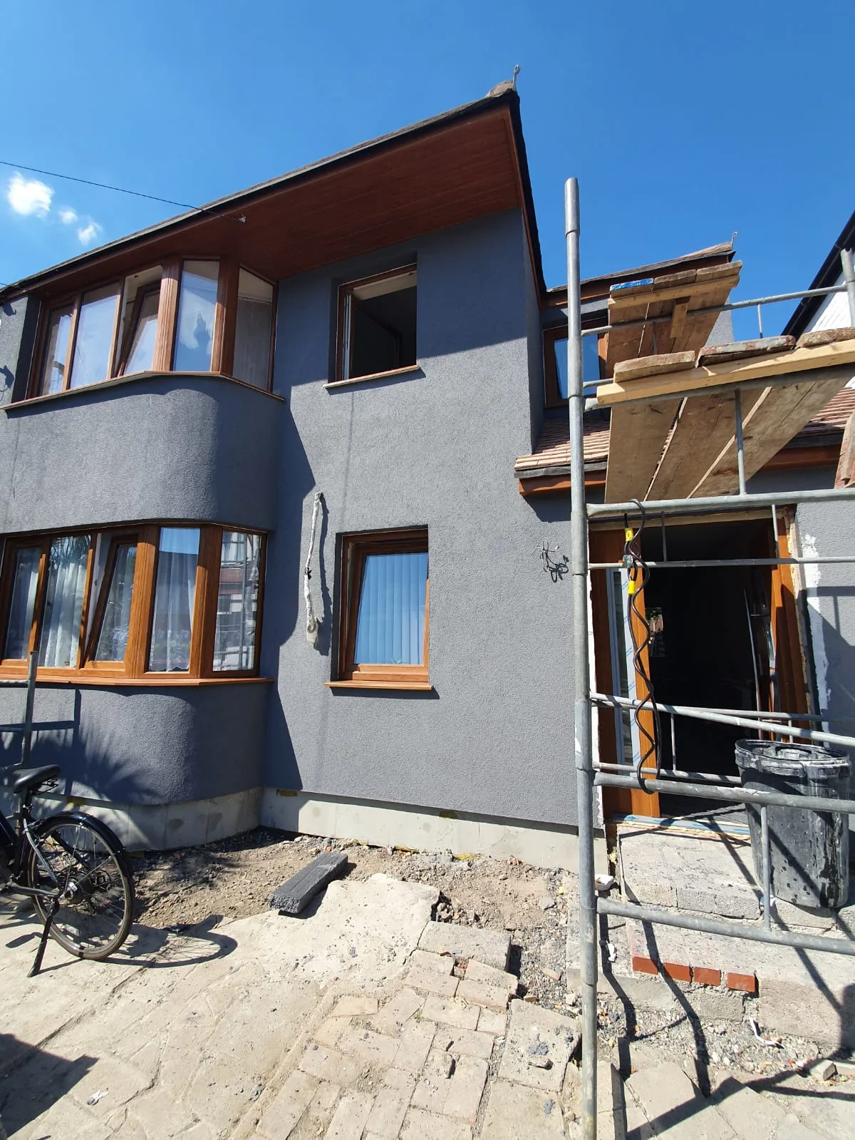 Recently renovated house exterior with scaffolding and clear blue sky