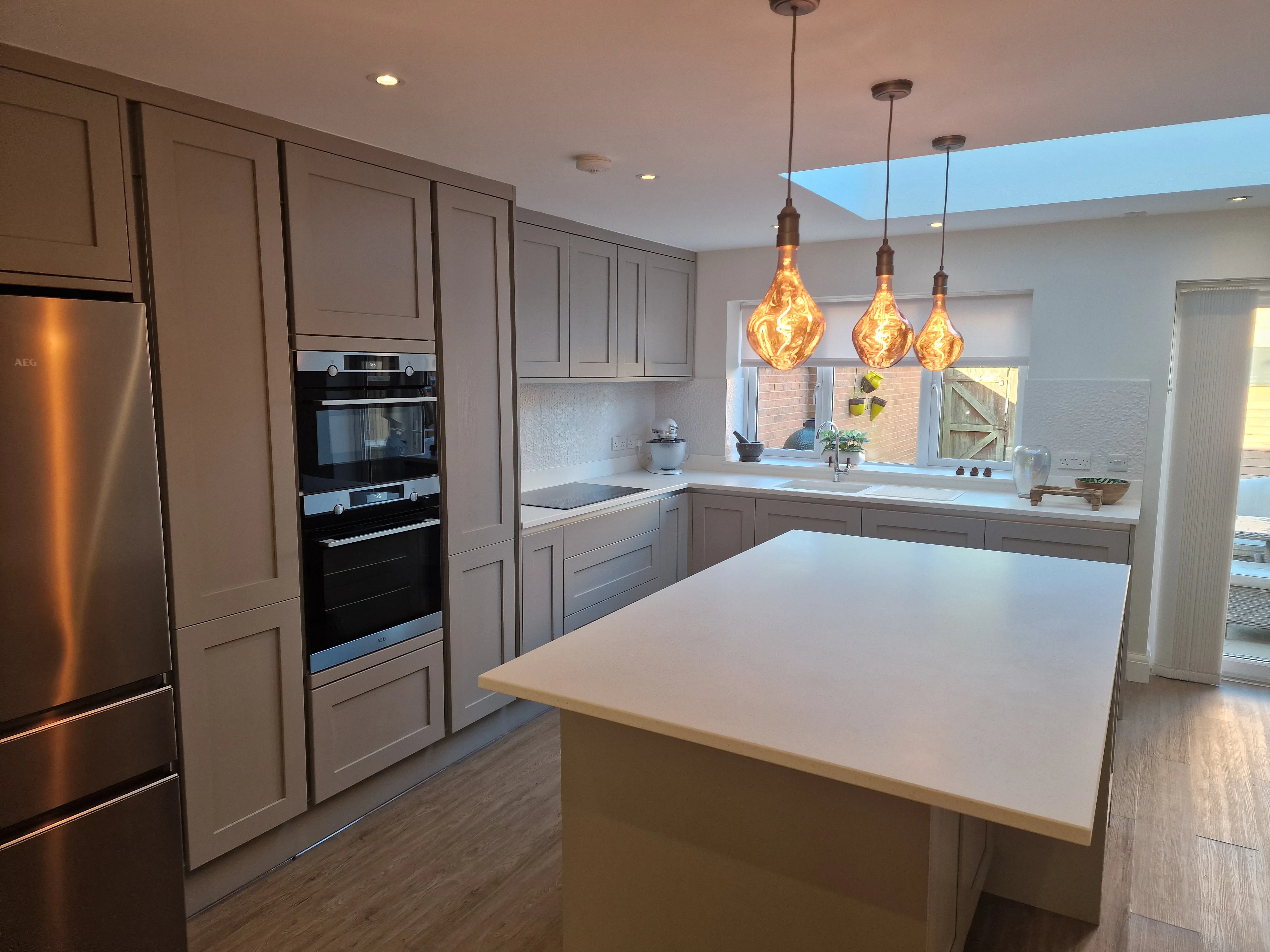 Modern kitchen renovation featuring a central island, stylish lighting, and integrated appliances