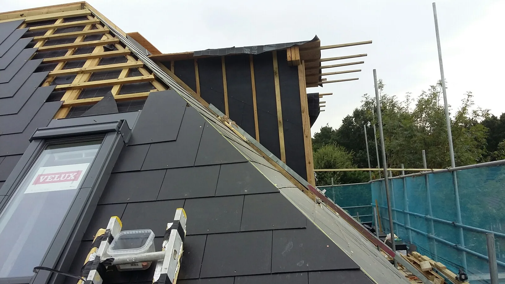 Roof installation in progress, showcasing new shingles and structure framing