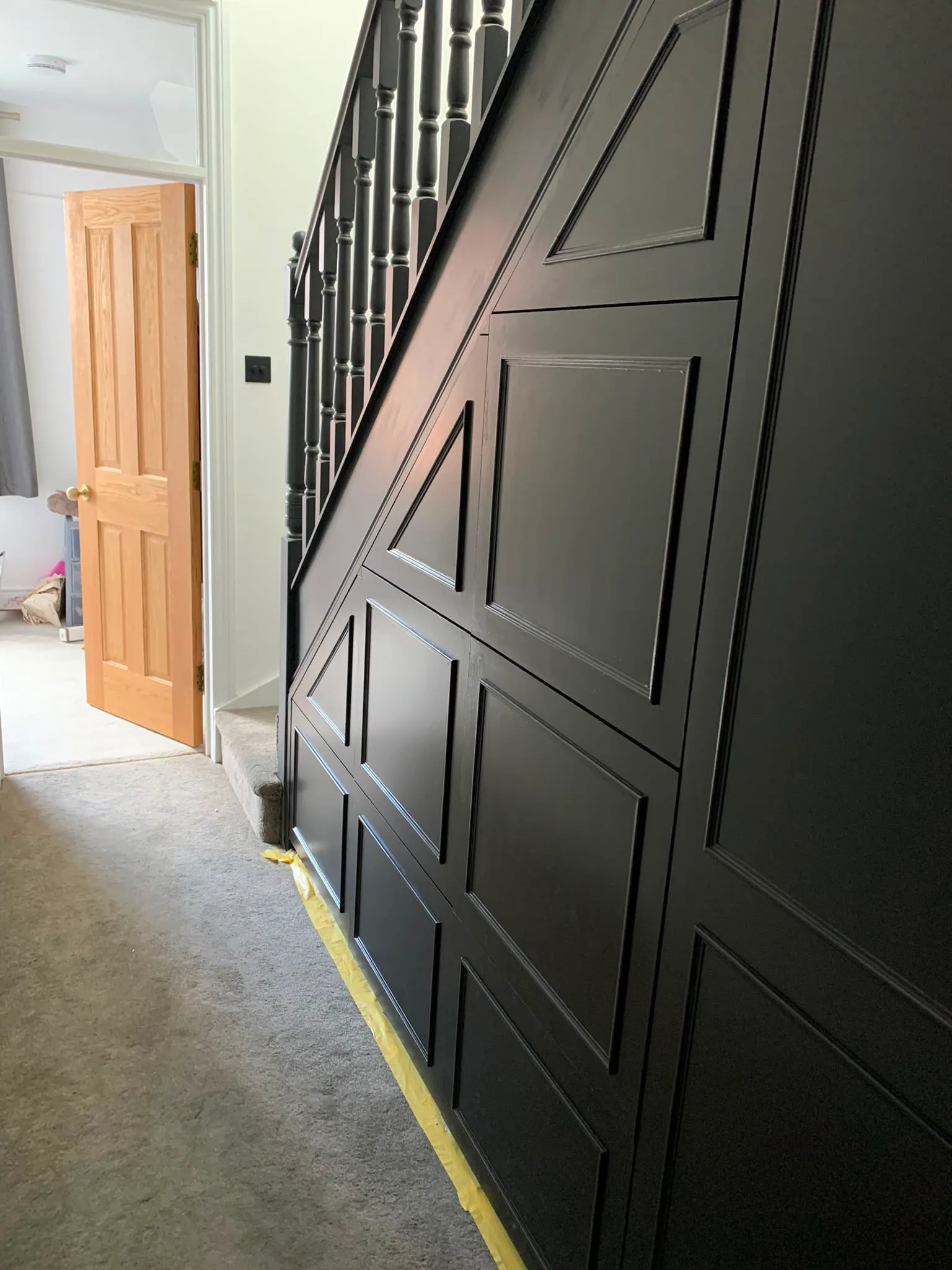 A close-up of a stylish black paneling on a staircase wall, showcasing detailed craftsmanship