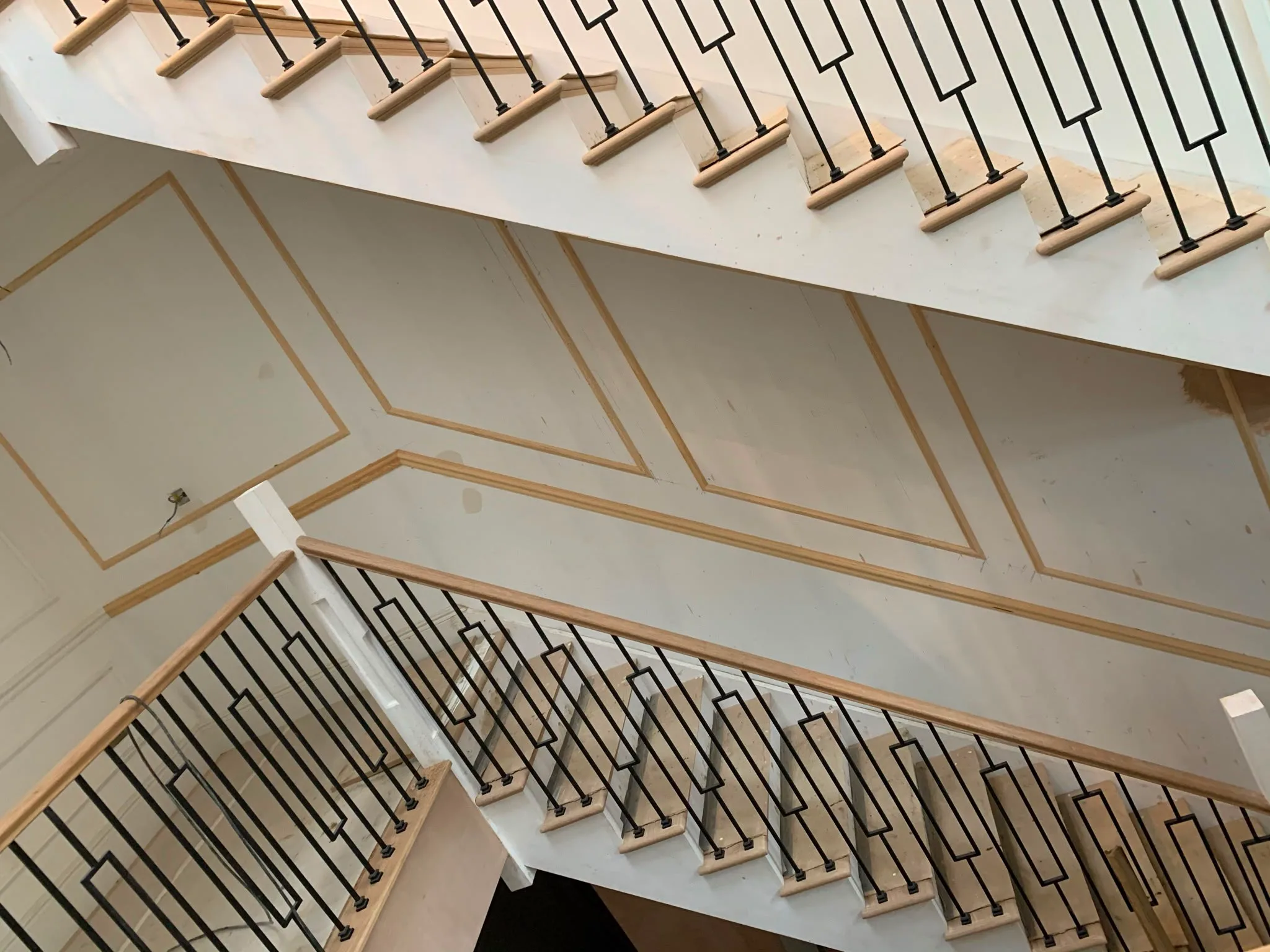 Interior staircase with minimalist railings and decorative wall paneling