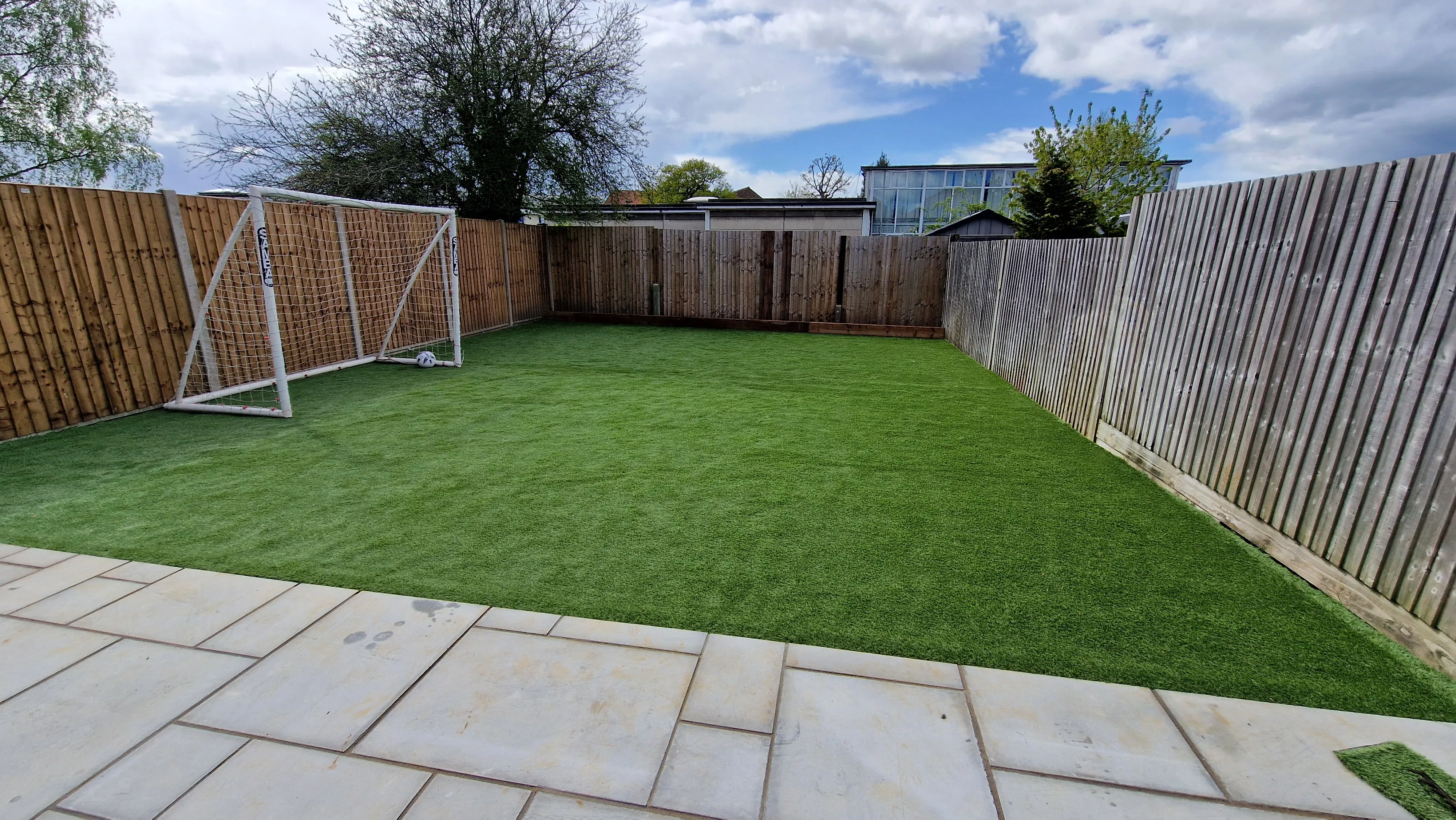 A newly landscaped garden with artificial grass and a goal post