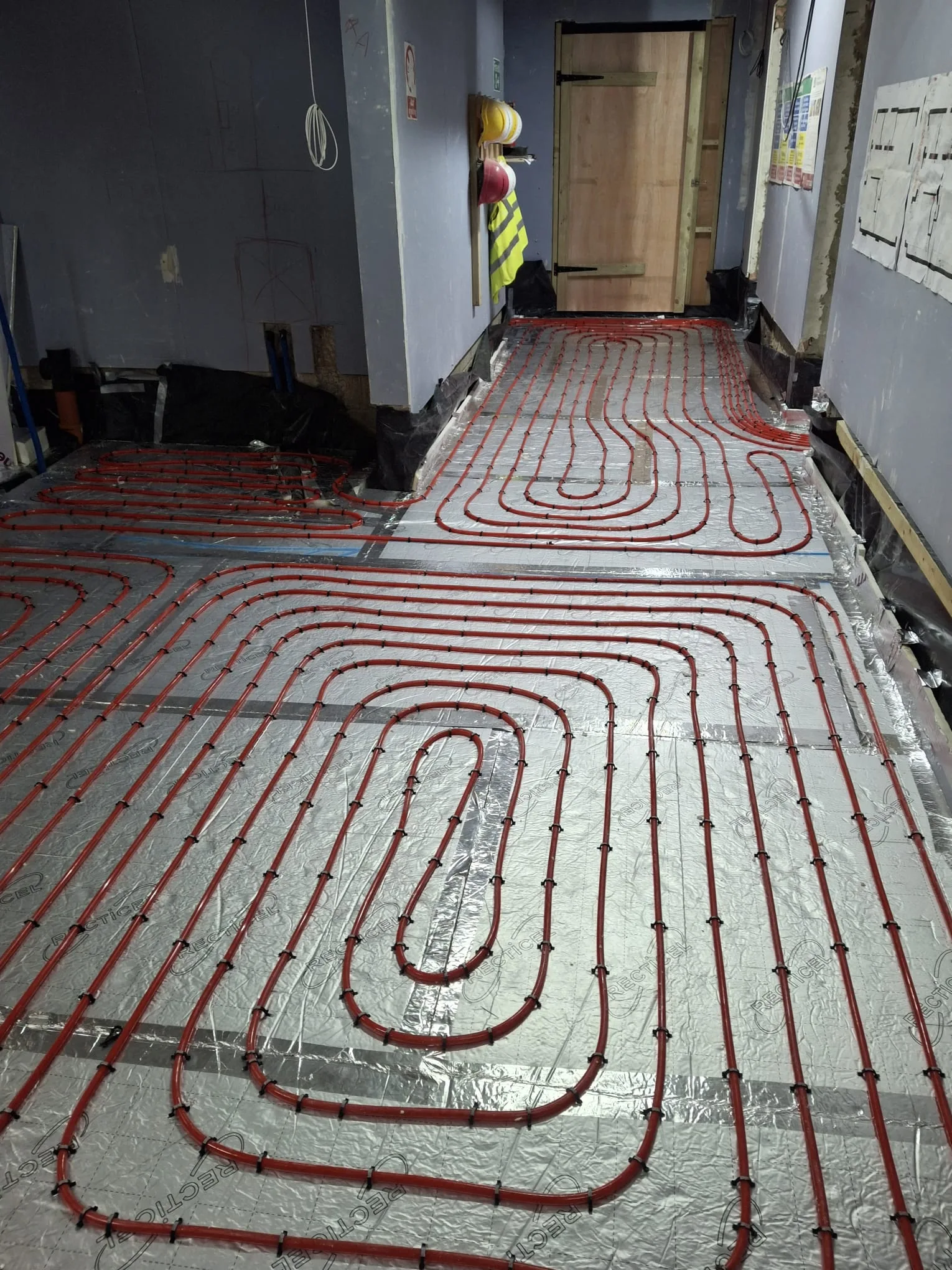 Underfloor heating installation visible on the floor with pipes laid in a pattern